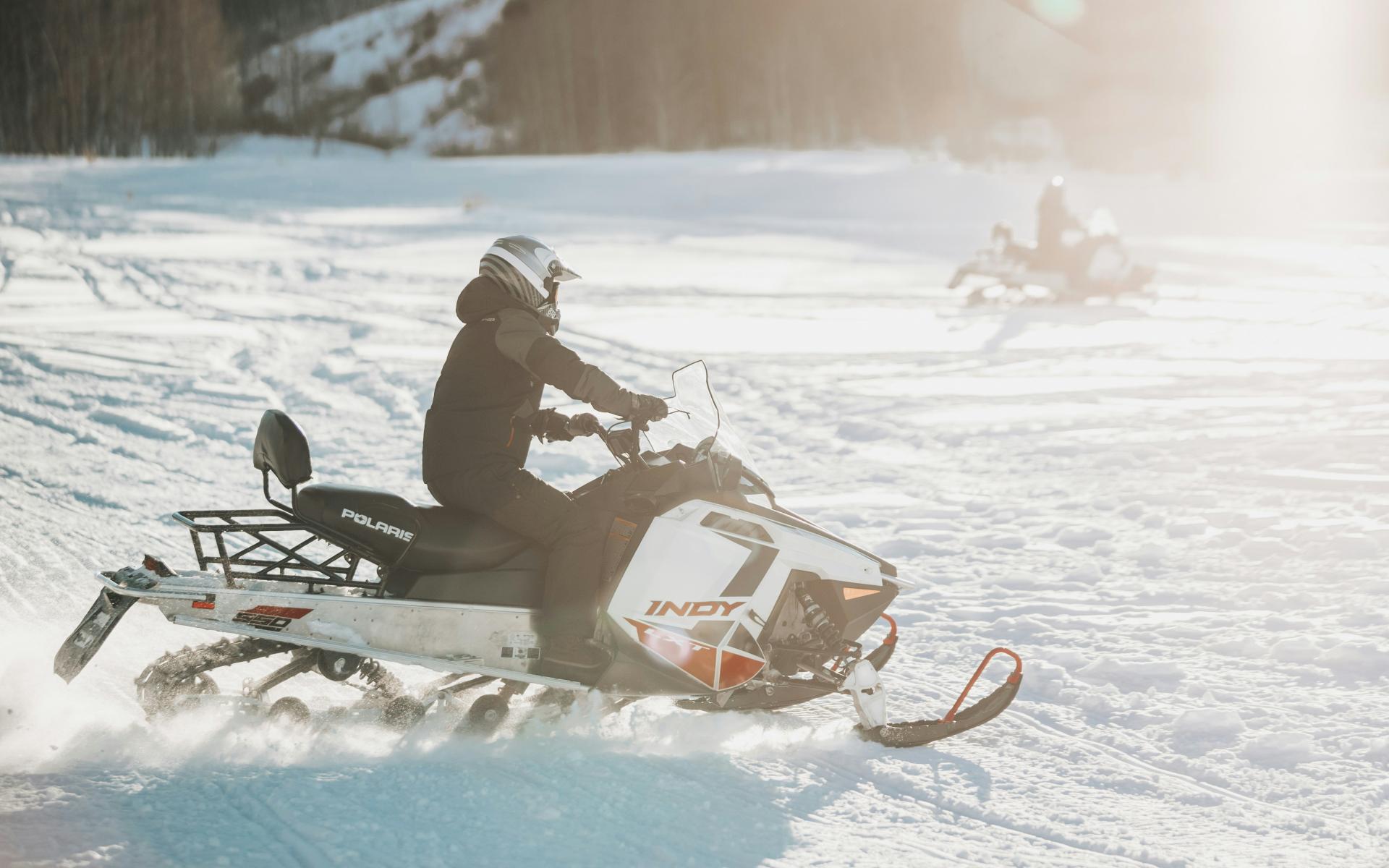 Two snowmobilers racing across the snow